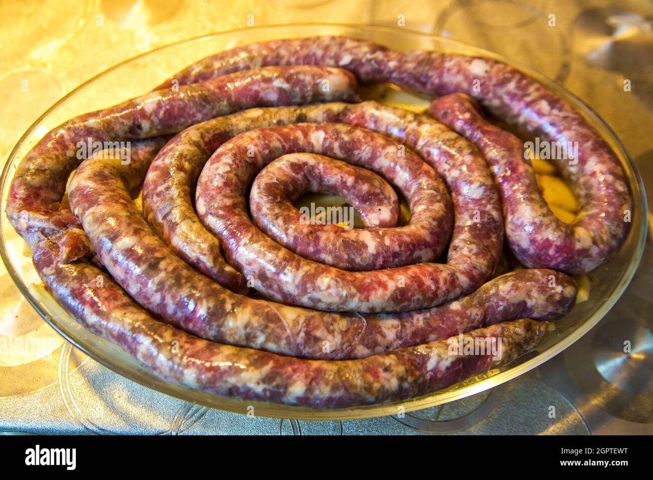 Homemade Sausages On Potatoes Prepared For Cooking. Traditional European Cuisine. Stock Photo