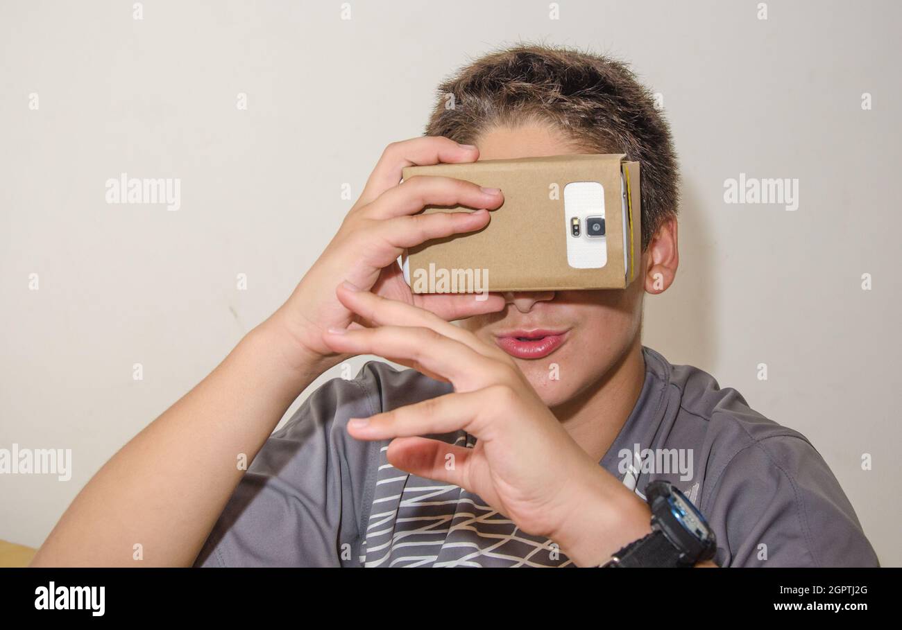 Close-up Of Boy Looking In Smart Phone Through Cardboard Virtual Reality Simulator Stock Photo