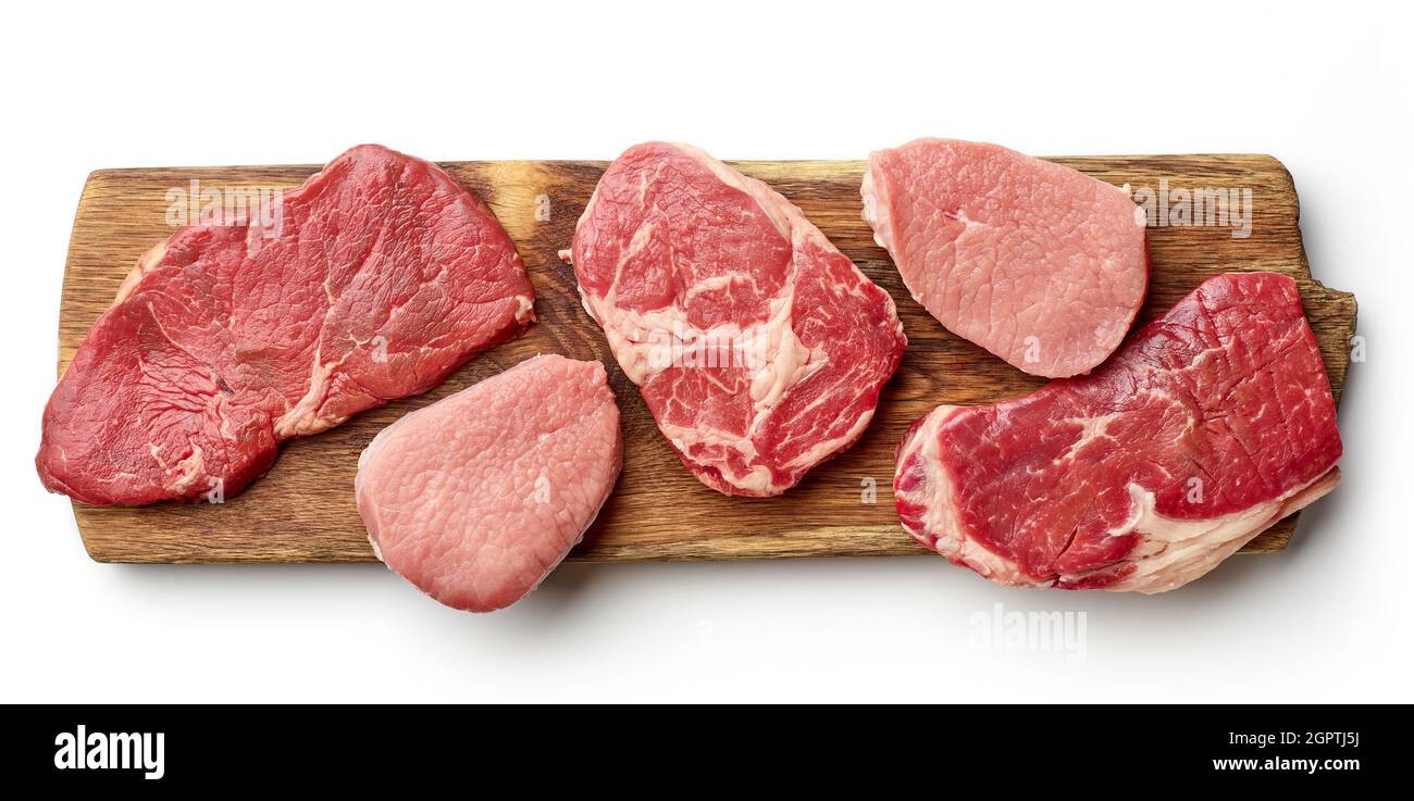Variety of steaks on wooden cutting board strip loin, entrecote, rump