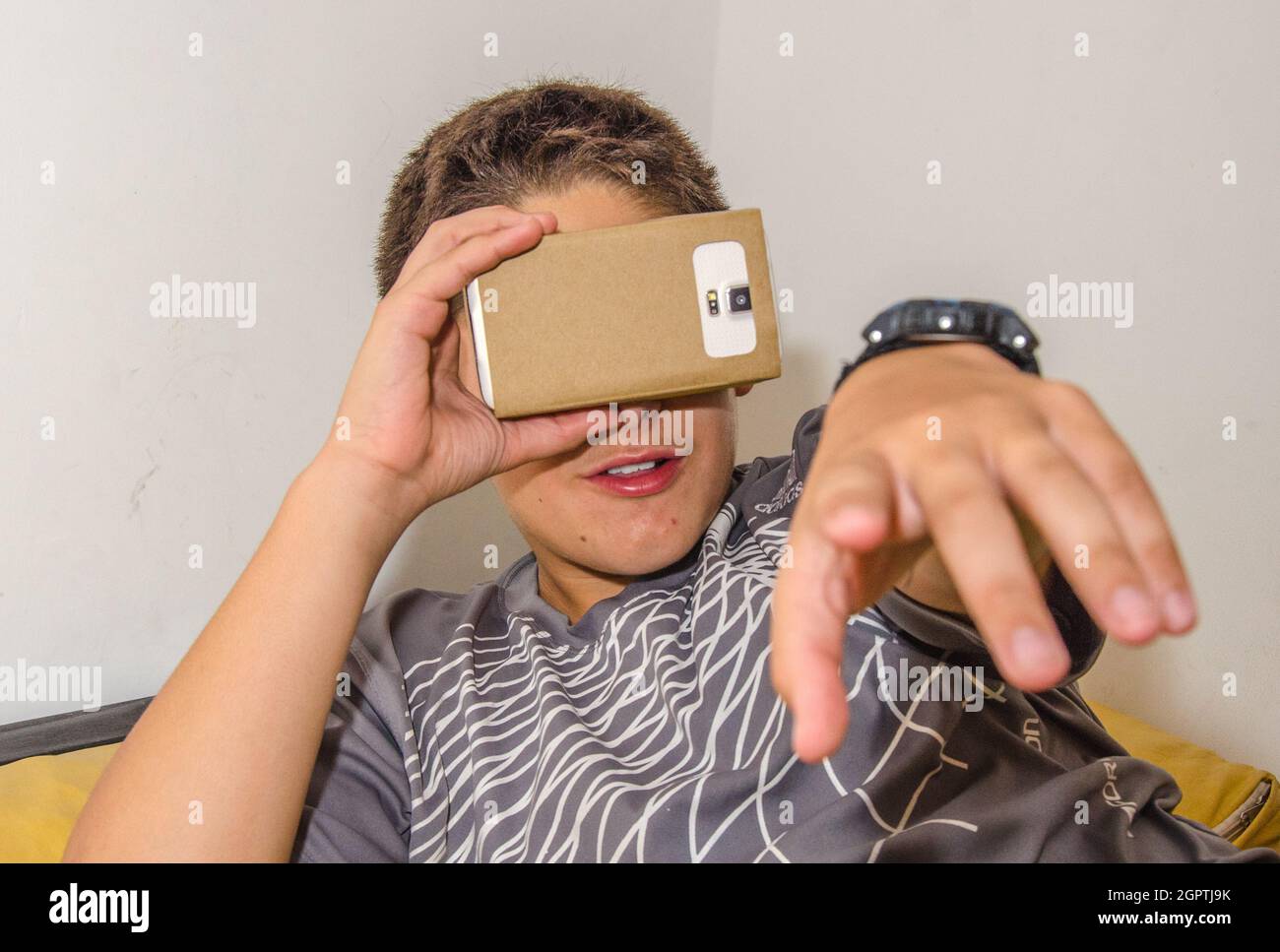 Close-up Of Boy Watching In Smart Phone Through Cardboard Virtual Reality Simulator Stock Photo