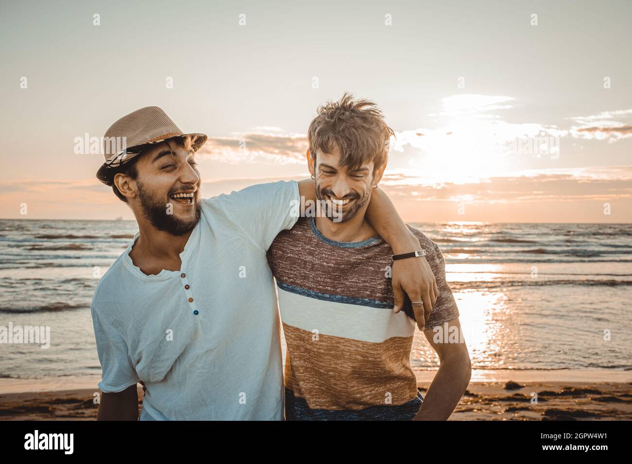 Two friends hug each other at the sunset on the beach. Friendship and love concept Stock Photo
