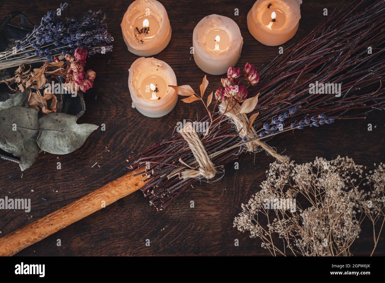 Decorated DIY besom broom for Samhain celebration. Hand made broom on a dark wooden table Stock Photo