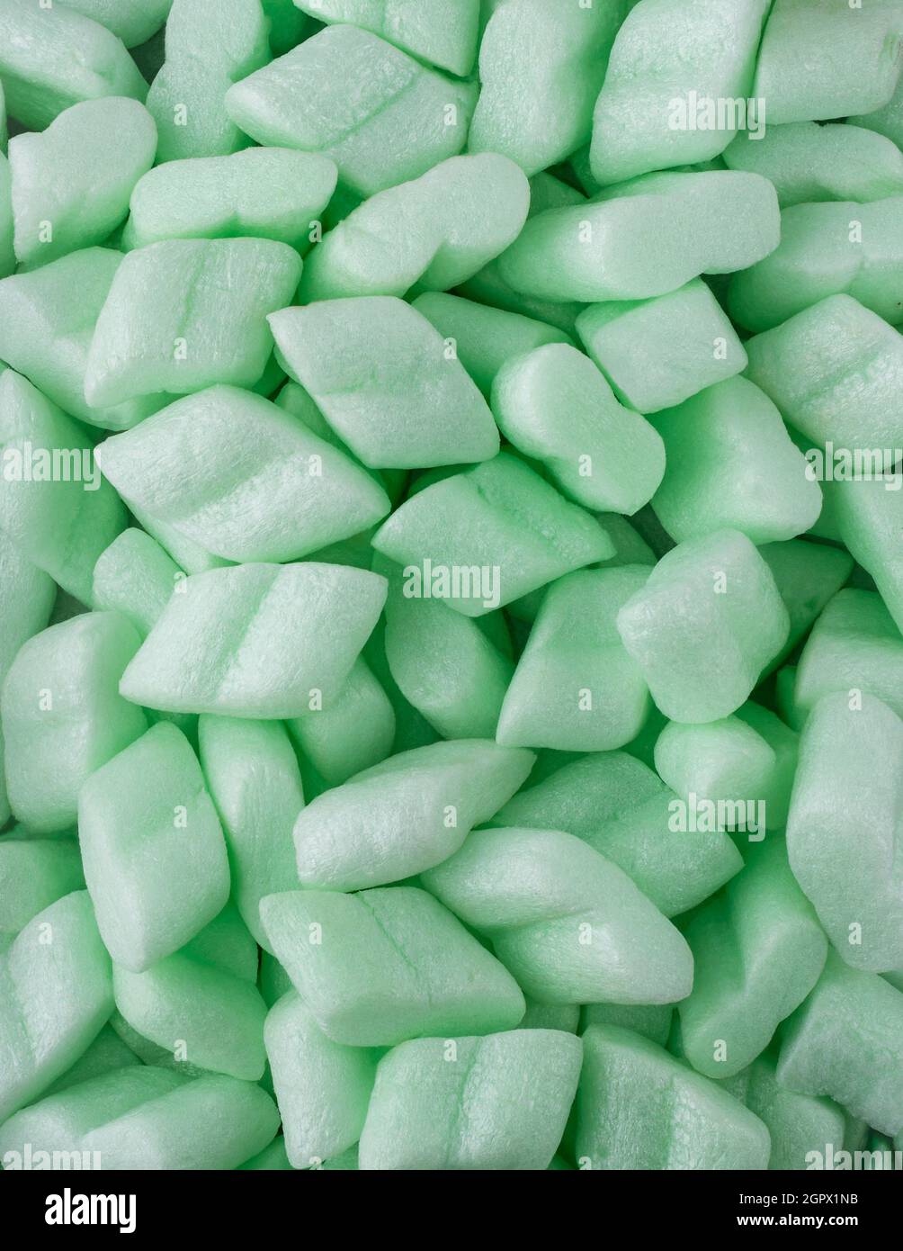 styrofoam packaging chips or peanuts, closeup of light weight green packing and cushioning material background texture Stock Photo
