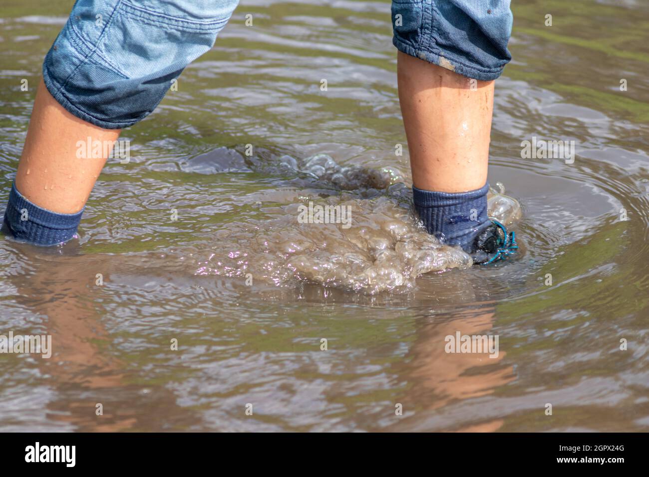 Young Boy With Blue Shorts, Wet Socks And Wet Shoes Stands In Floodwater  After The Dike Was Broken Stock Photo - Alamy