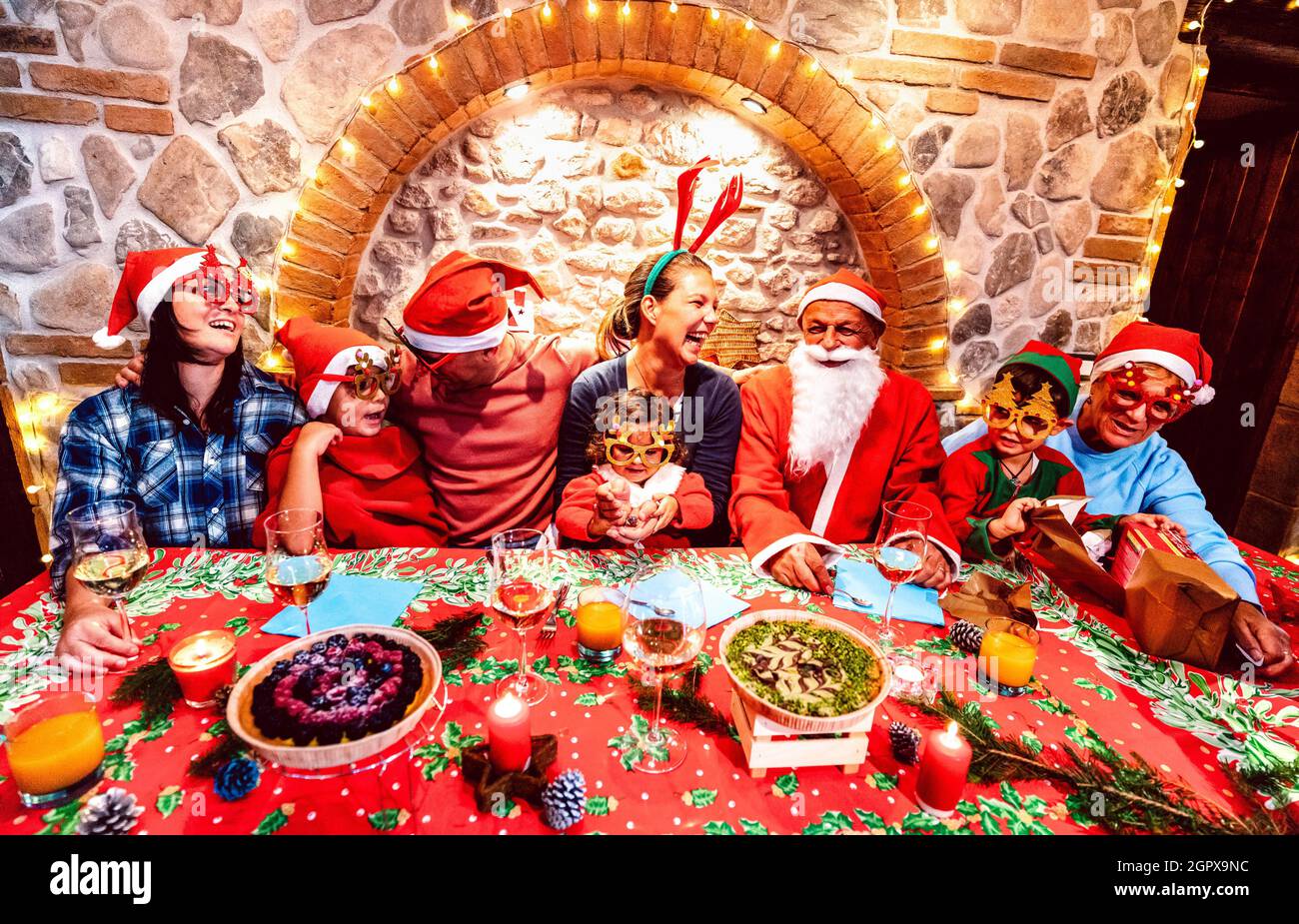 Group of multi generation large family with santa hats clothes having fun at christmas fest house party - Winter holiday xmas concept with parents Stock Photo