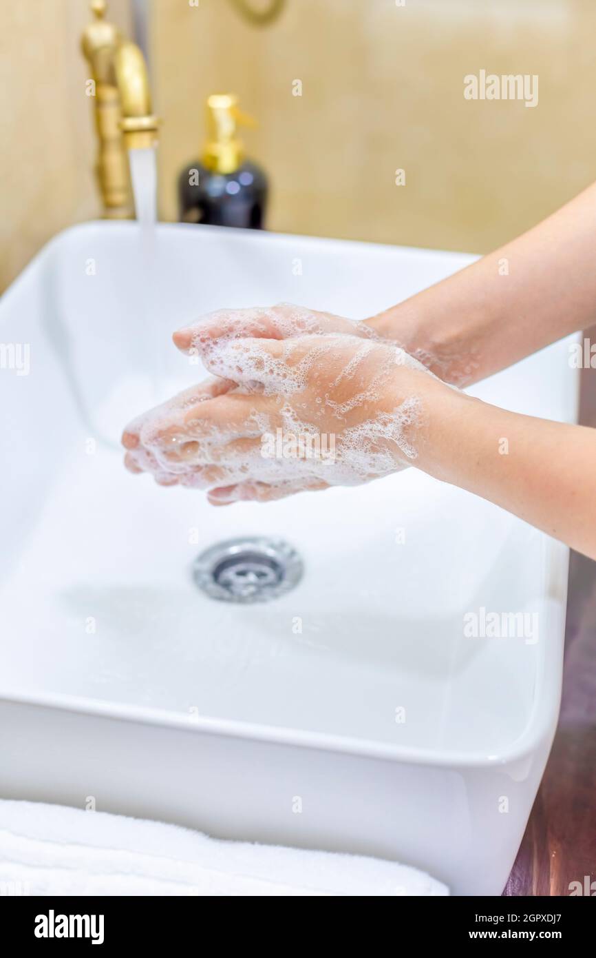 Woman Washing And Disinfecting Hands With Soap And Hot Water As Part Of Coronavirus Preventio. Stock Photo