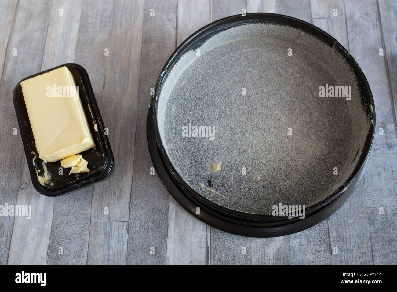 Step by step the process of making sour cream pie dough. Female hands prepare a baking dish, grease with butter and sprinkle with semolina. Baking con Stock Photo