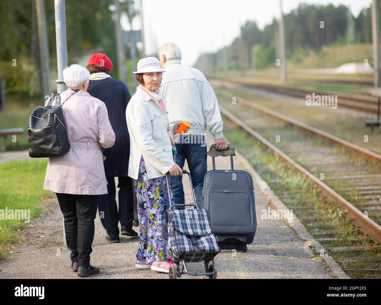 Group Of Seniors Elderly Old People With Luggage Waiting For A Train To