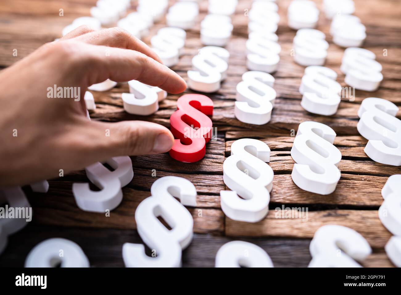 Person's Hand Holding Red Paragraph Sign. Law And Regulation Stock Photo