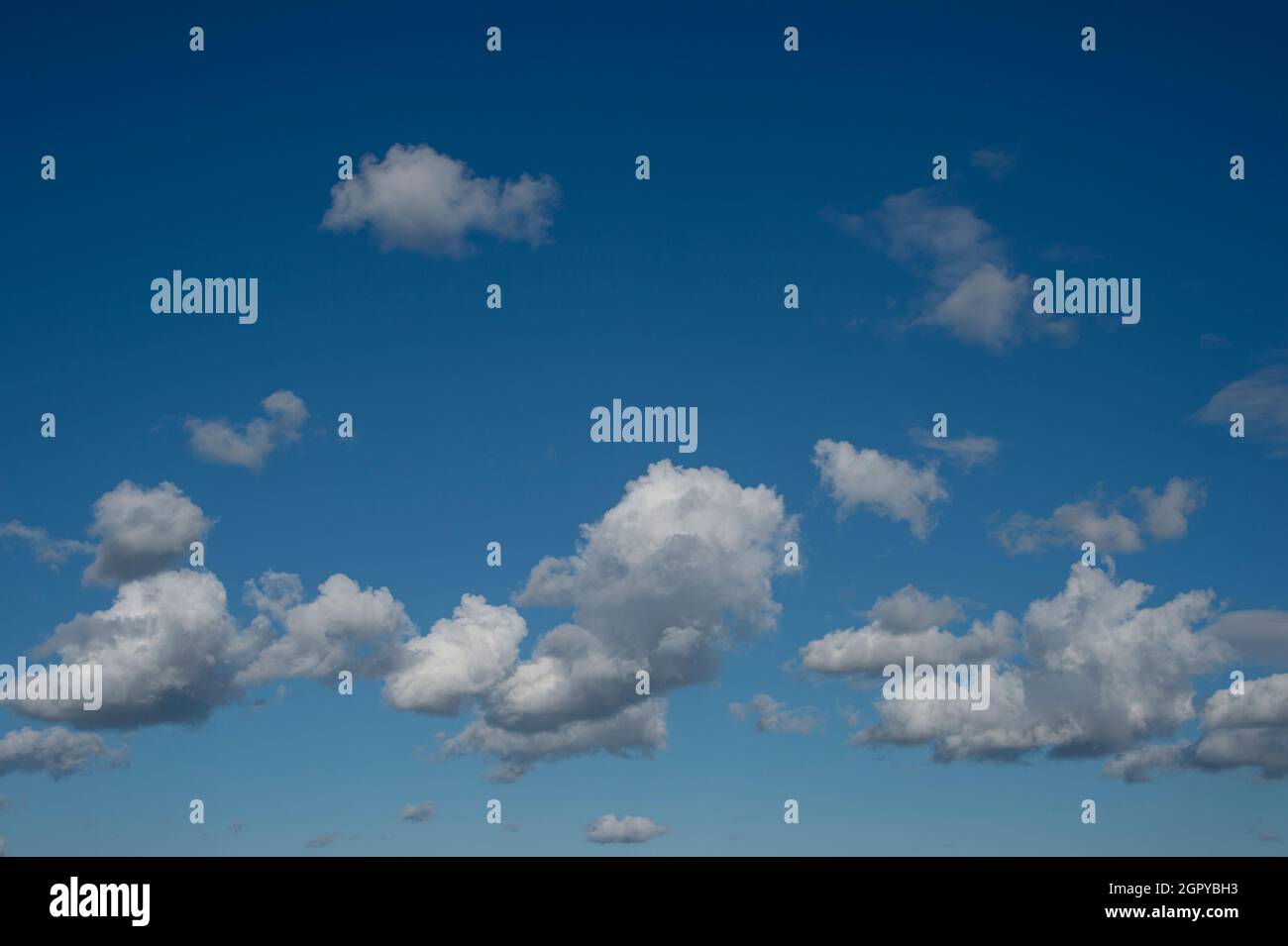 fluffy white clouds against a blue sky. Stock Photo