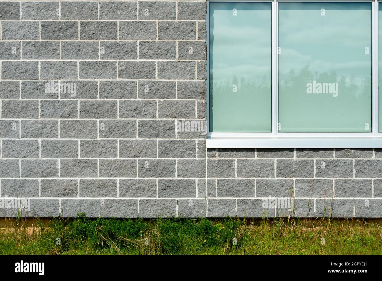 The exterior of a commercial building is built of grey stone brick with