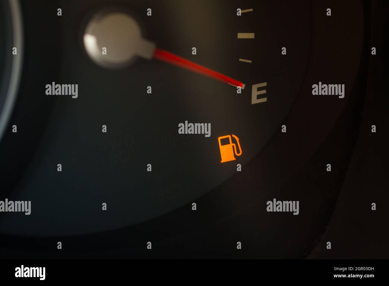 Empty fuel gauge warning light in car dashboard close up view. Fuel