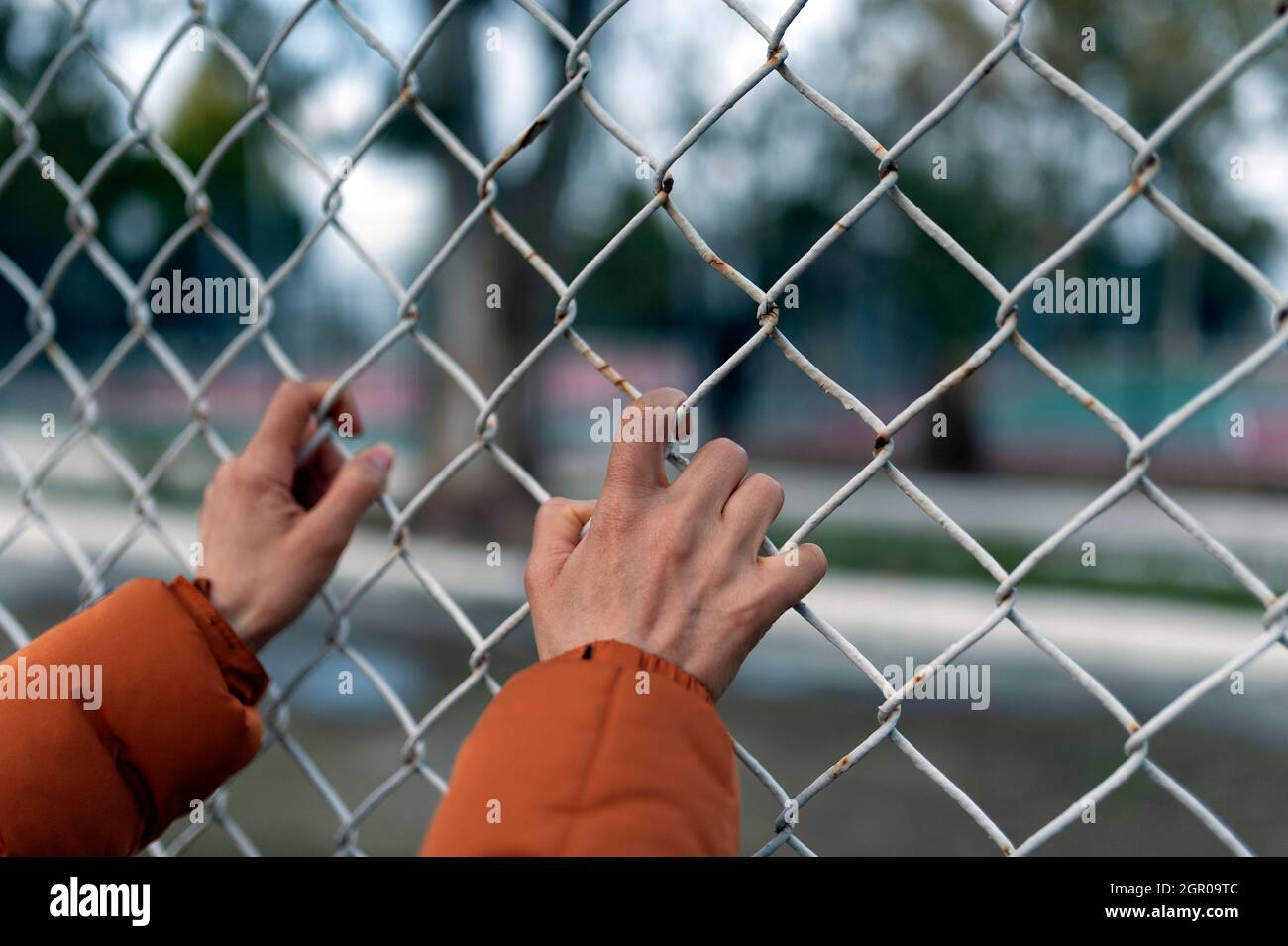 Woman hands holding fence Stock Photo
