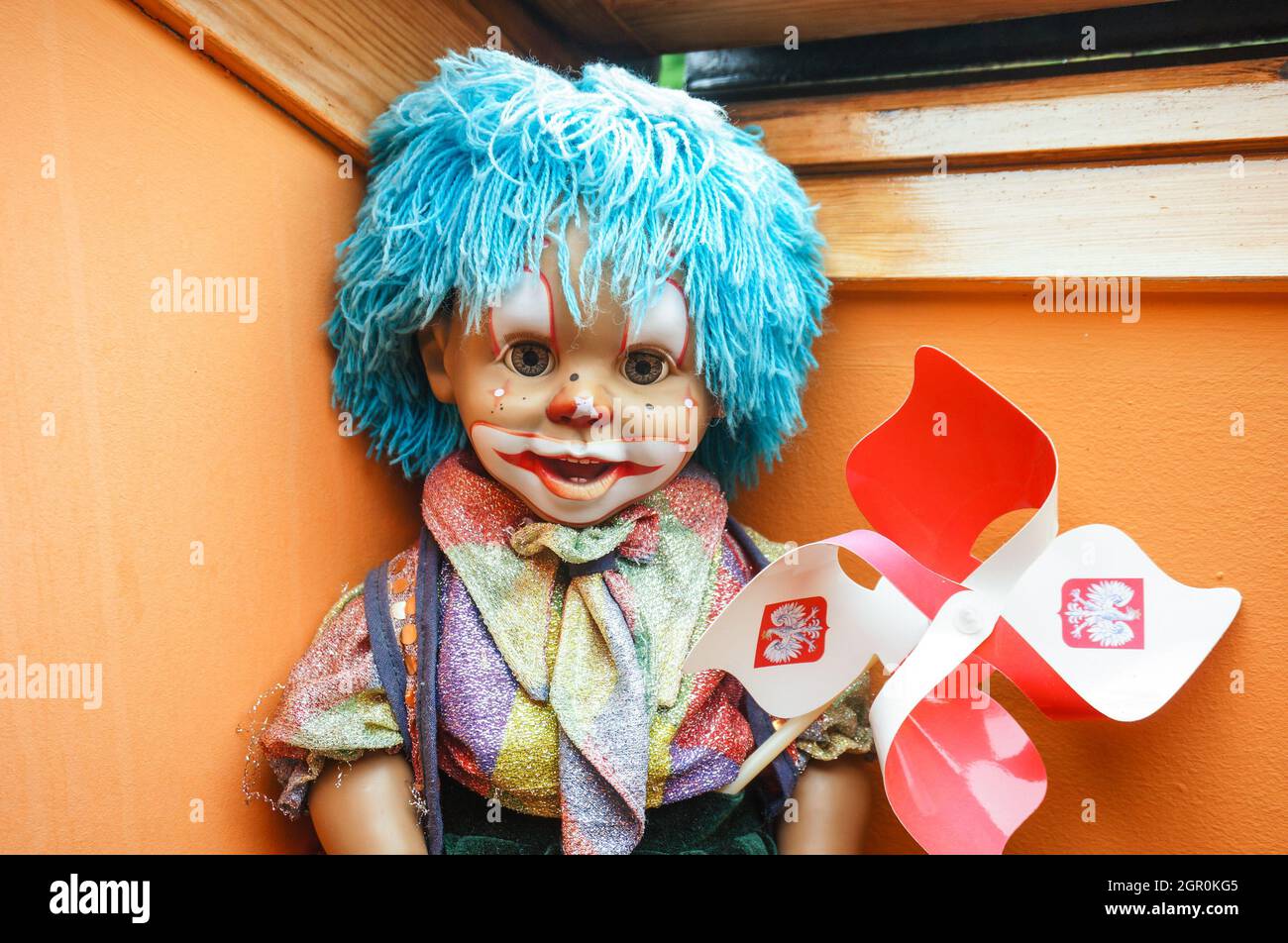 POZNAN, POLAND - Jun 11, 2016: A sitting clown doll holding a Polish fan article. Stock Photo