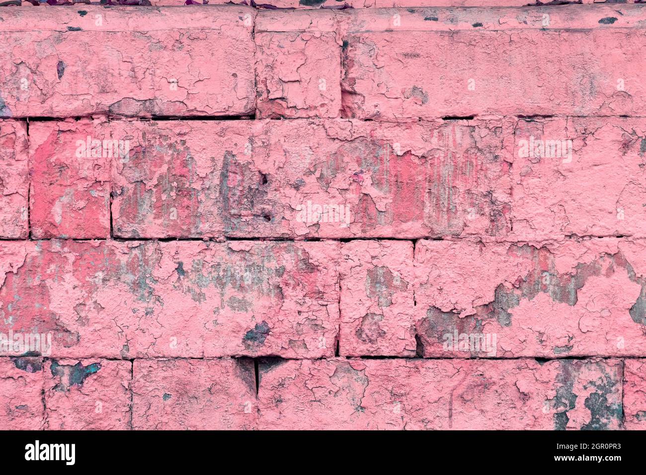 peeled off old pink paint on flat rough brick wall surface - full frame background and texture Stock Photo