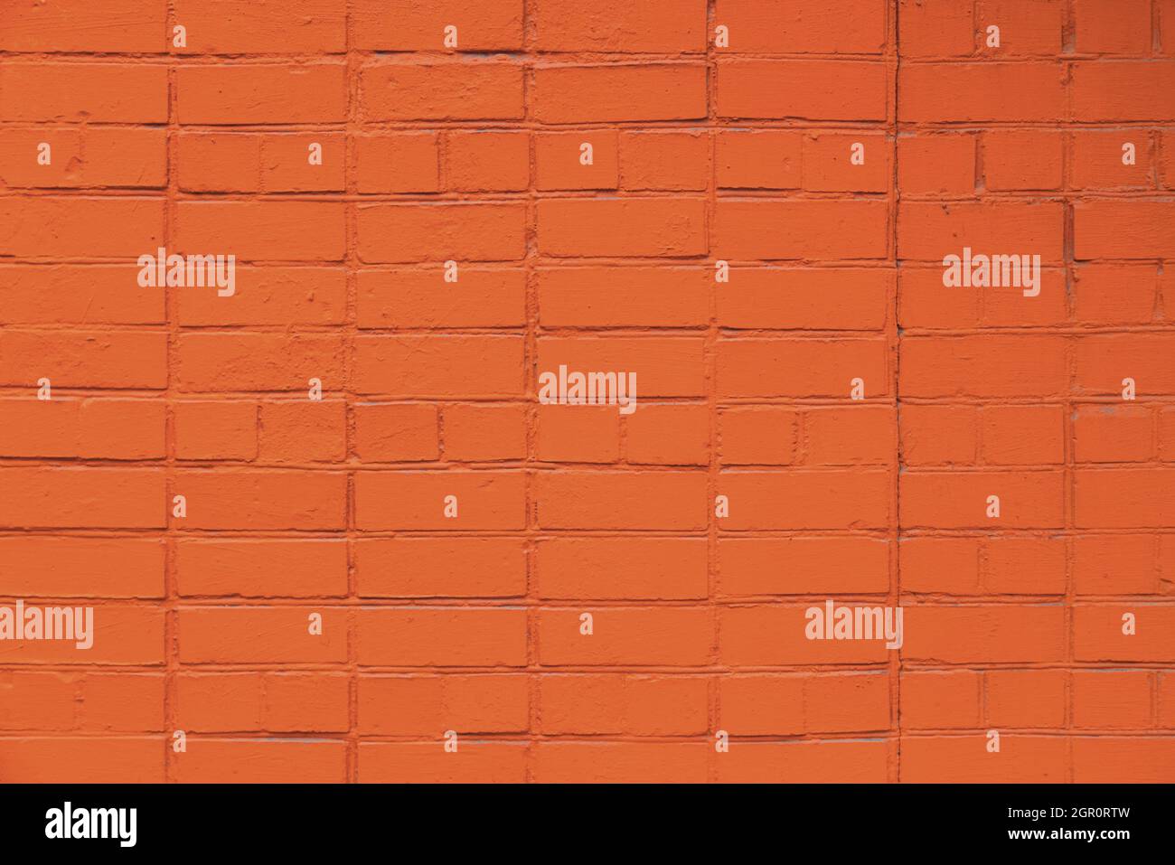 matte orange painted brick wall full frame flat background and texture Stock Photo