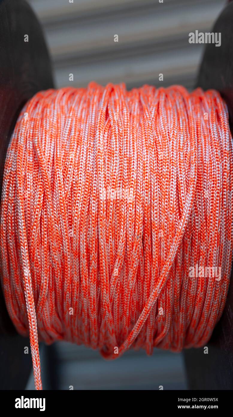 Orange colored rope, Orange colored thick braided rope, Orange colored lanyard, Orange colored cord, Orange colored tightrope Stock Photo