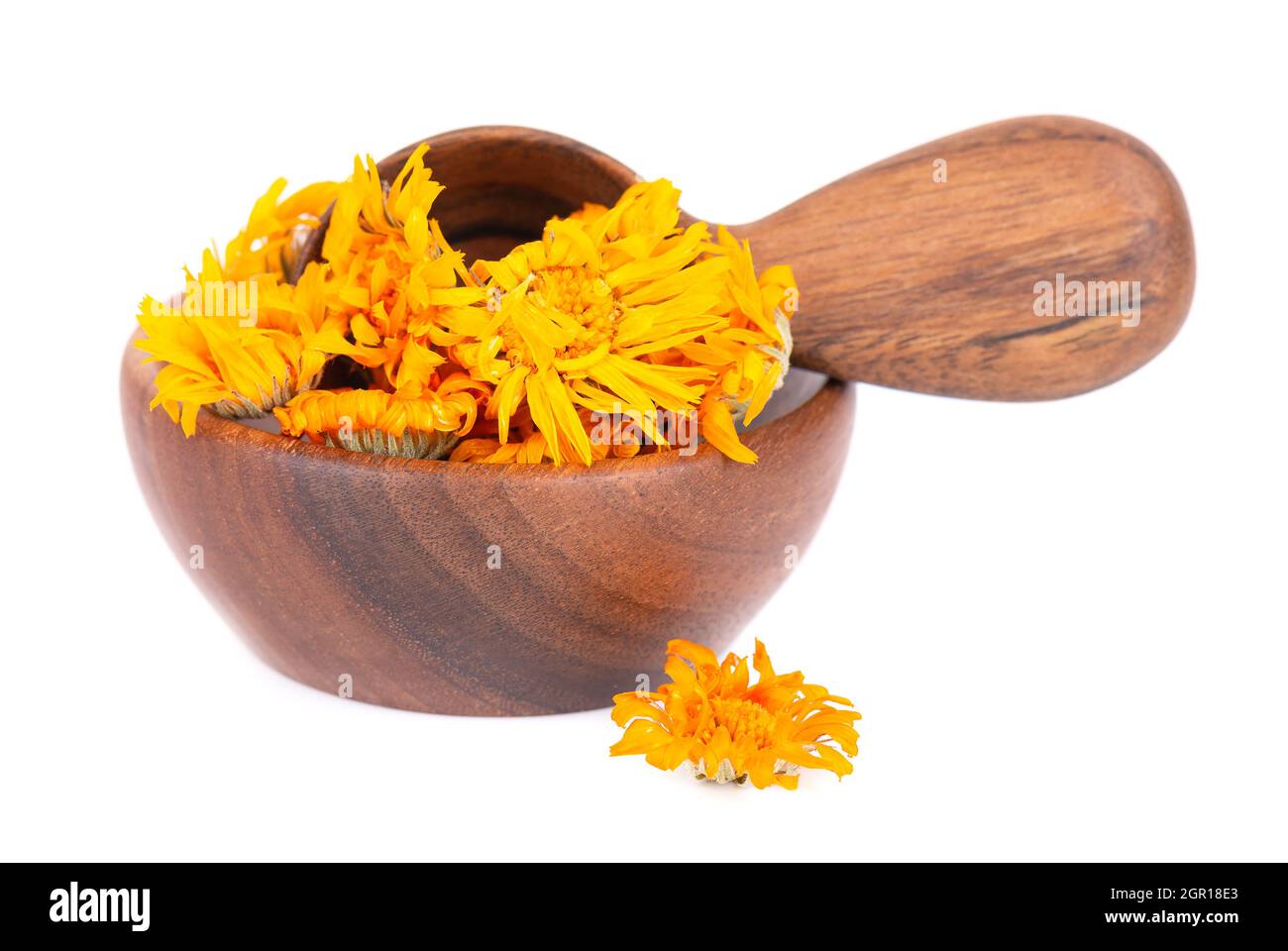 Dried calendula flowers in wooden bowl and spoon, isolated on white background. Petals of