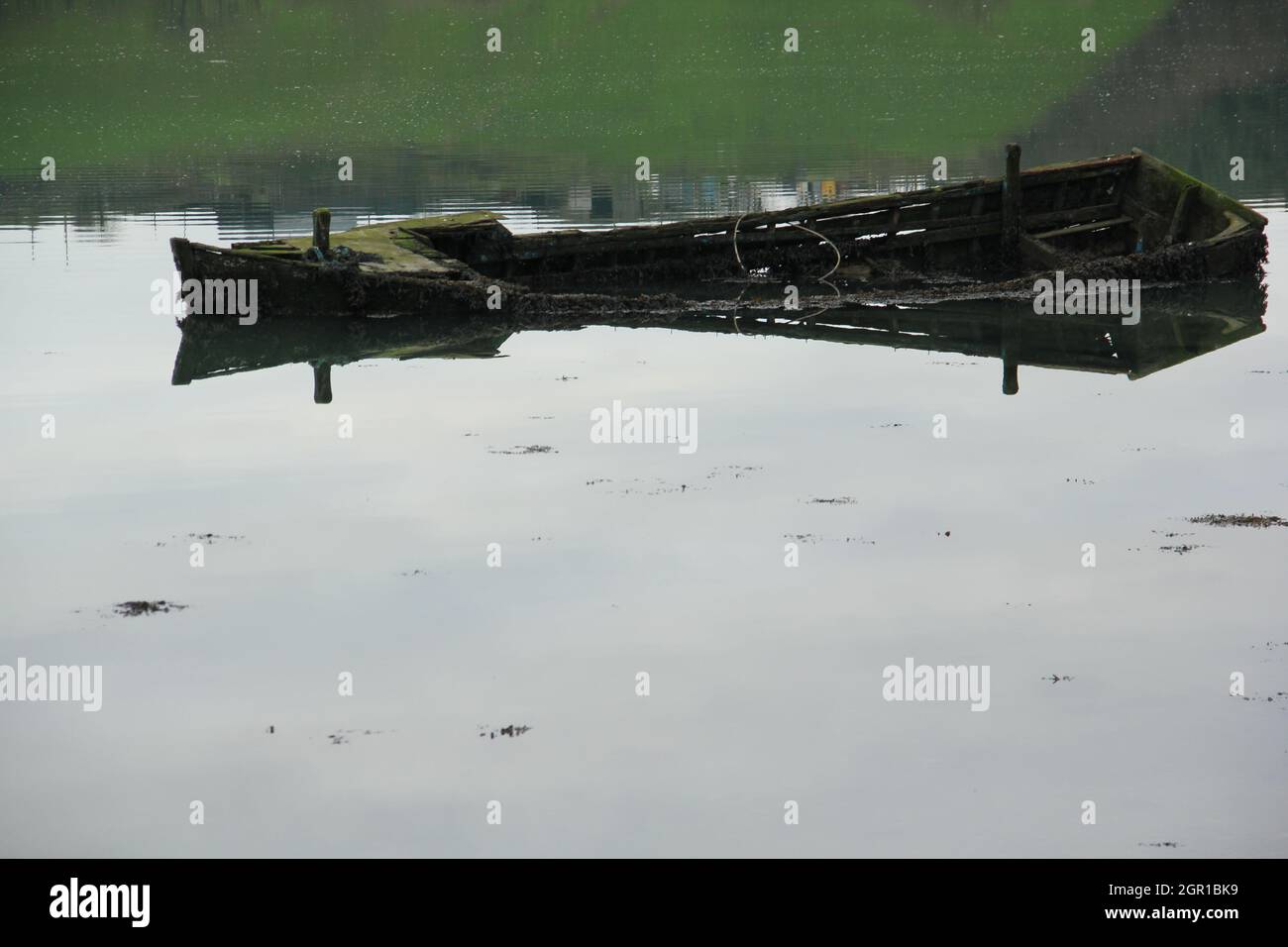 Wrecked rotting hulk lying in shallow water Stock Photo