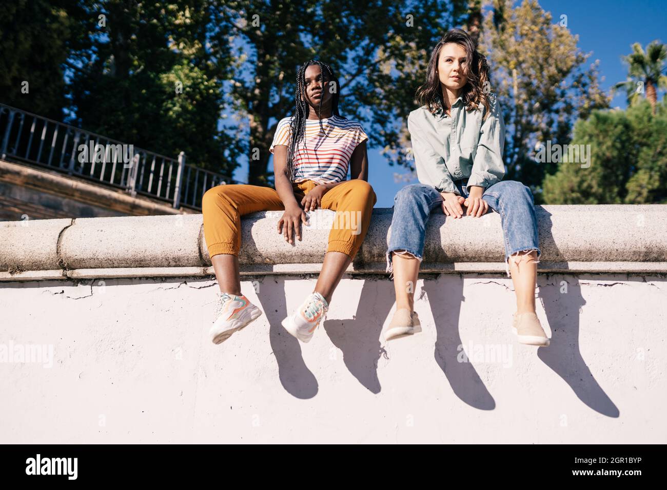 Girl sitting on wall low angle hi-res stock photography and images - Alamy