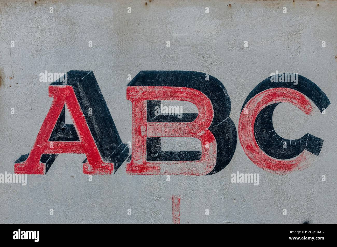 the letters A B C written on a wall in signwriting signwritten alphabetical figures and painted on a shabby wall. Stock Photo