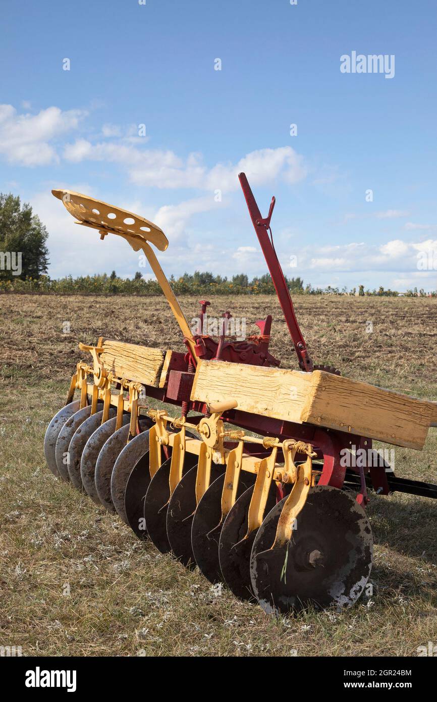 Old disc harrow or discer, an antique piece of farm equipment used to till soil, in the Canadian prairies Stock Photo