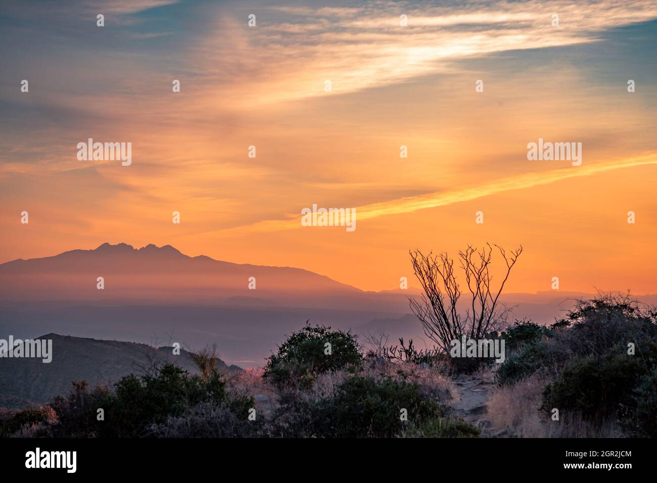 Scenic View Of Silhouette Mountains Against Orange Sky During Sunrise Stock Photo