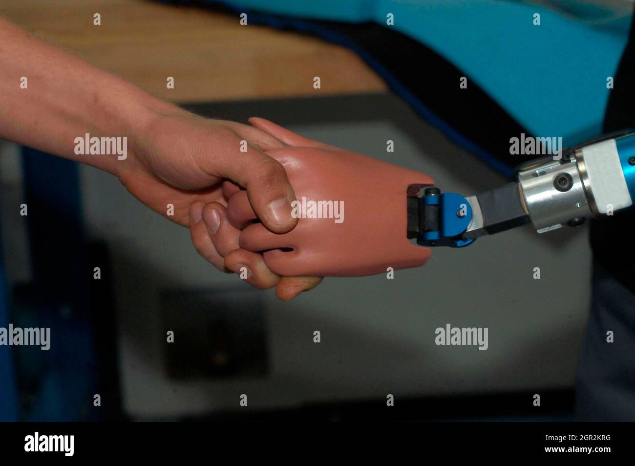 Cropped Image Of Man Doing Handshake With Robotic Arm Stock Photo