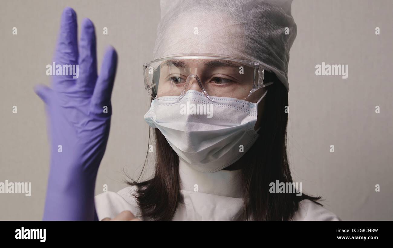 Female Medic Puts On Rubber Glove Stock Photo - Alamy