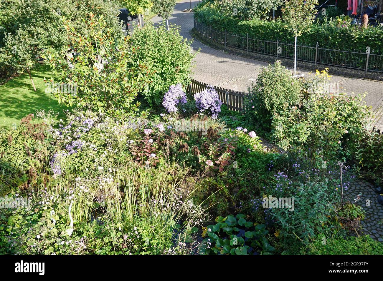 mit bunten Blumen und Gartenteich, Gegenentwurf zum öden