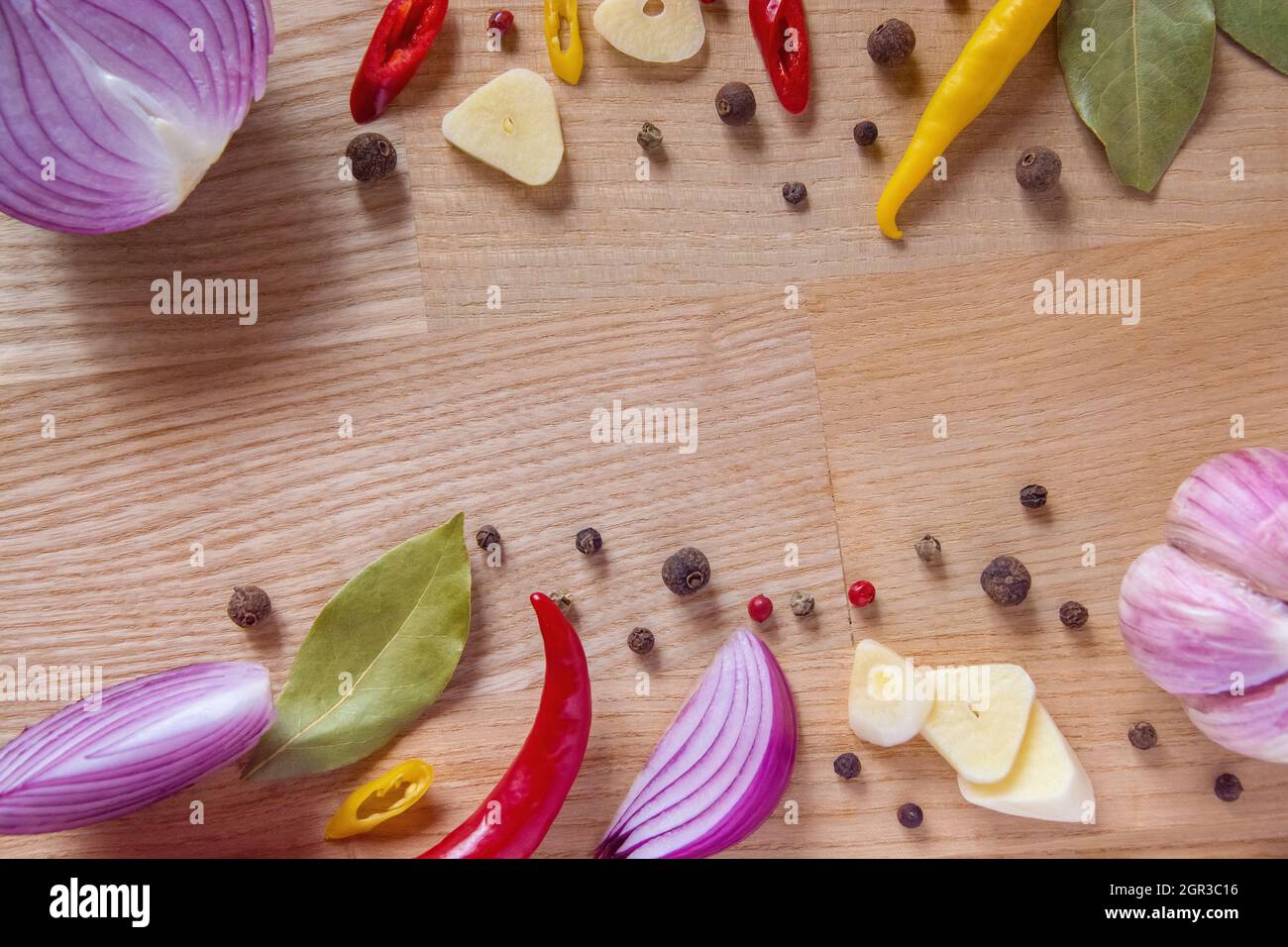 Set of vegetables from onion, garlic, hot pepper, bay leaf and spices on a wooden background. High quality photo Stock Photo