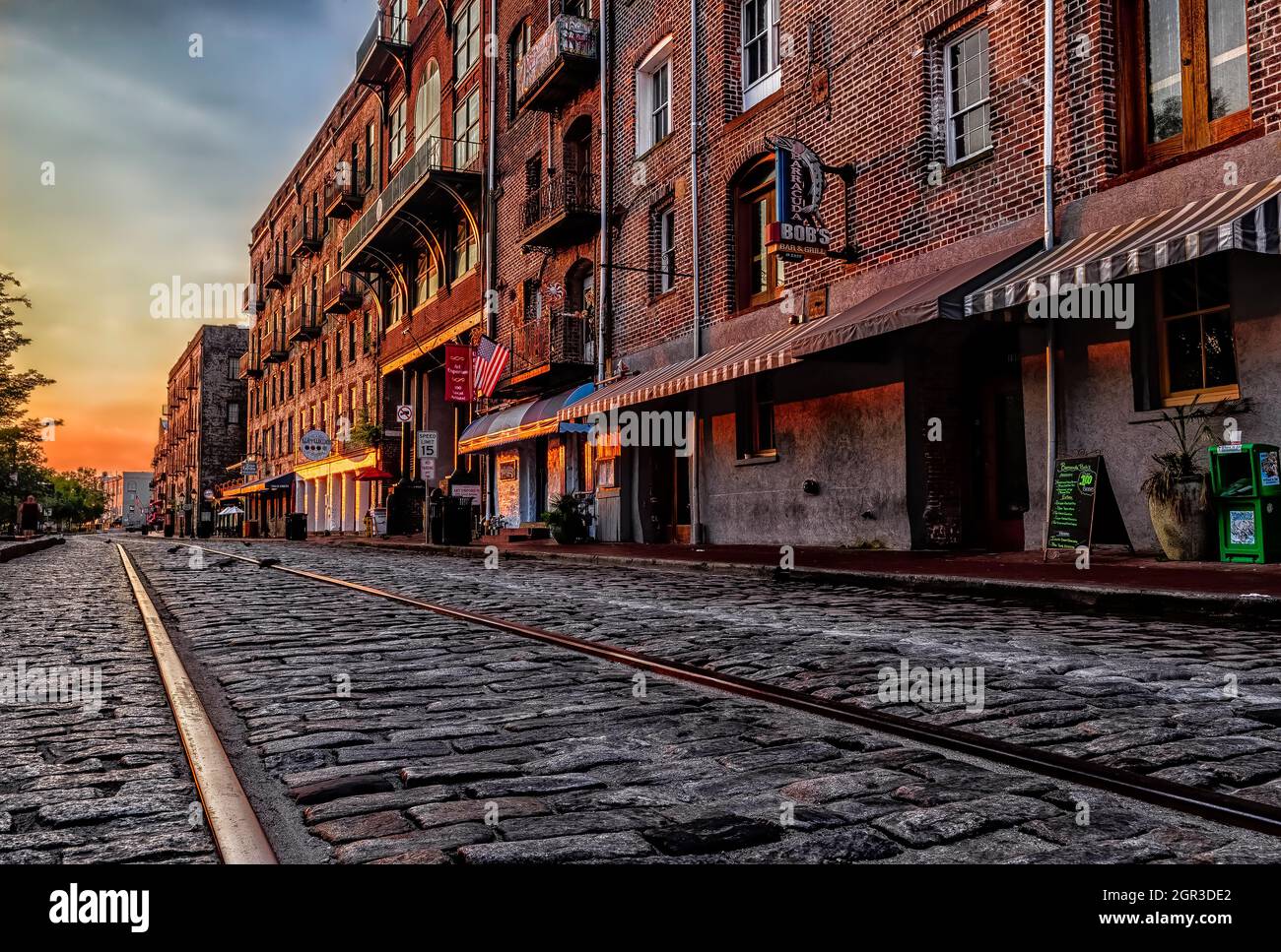 River Street Line's streetcar tracks glisten at Sunrise on River Street, Savannah, Georgia Stock Photo