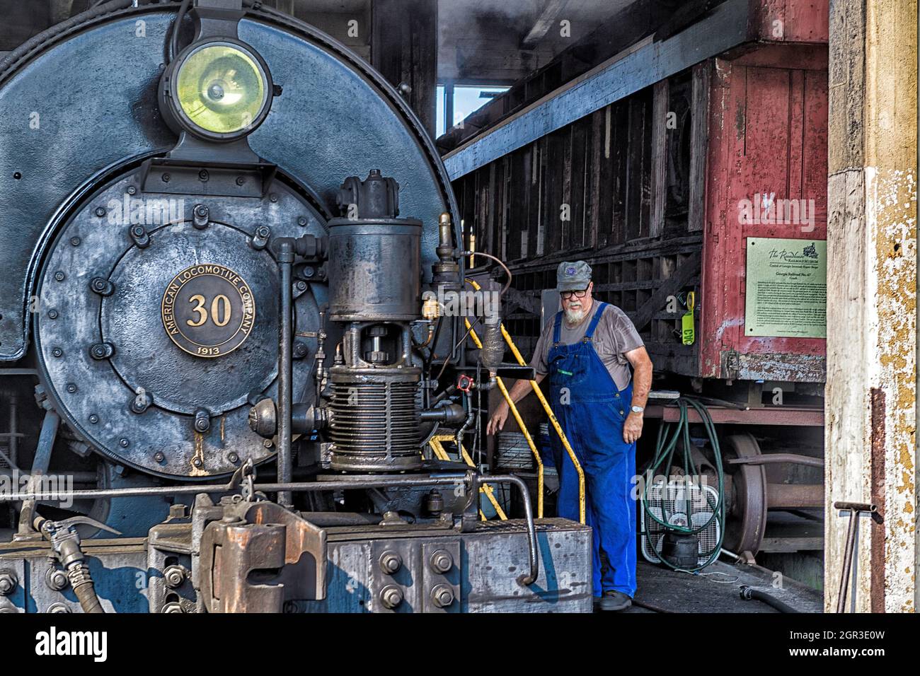 Engine driver inspecting the exterior of the historical Savannah Central #30 steam locomotive located at the Georgia State Railroad Museum Stock Photo