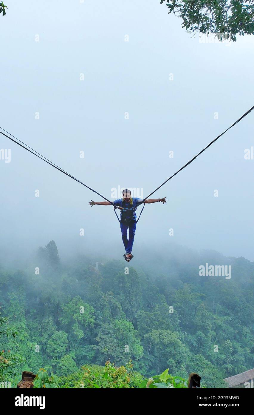 A Man Swing In The Sky By Rope Stock Photo - Alamy