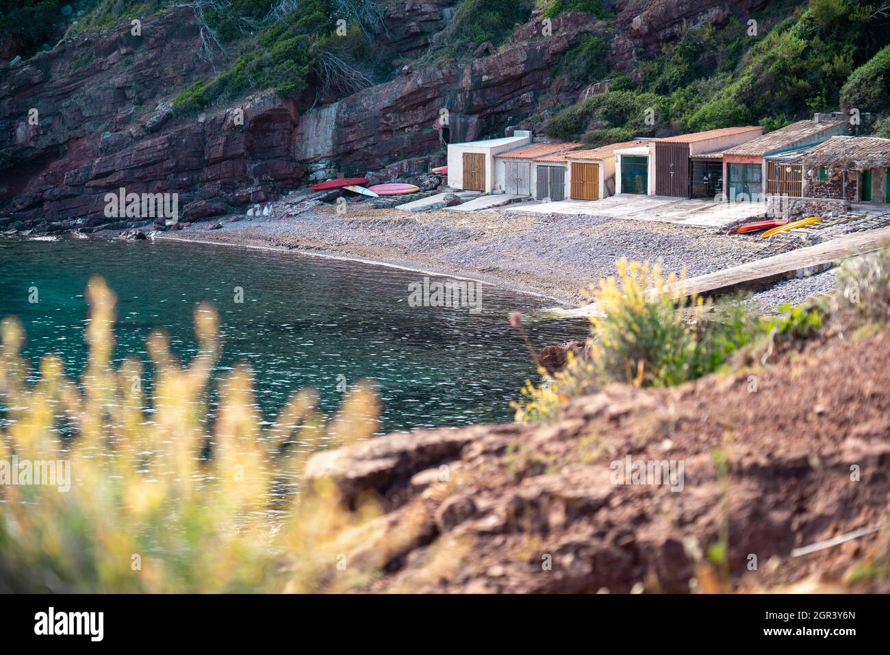 Plants By Sea And Small Cove Against Mountain Stock Photo