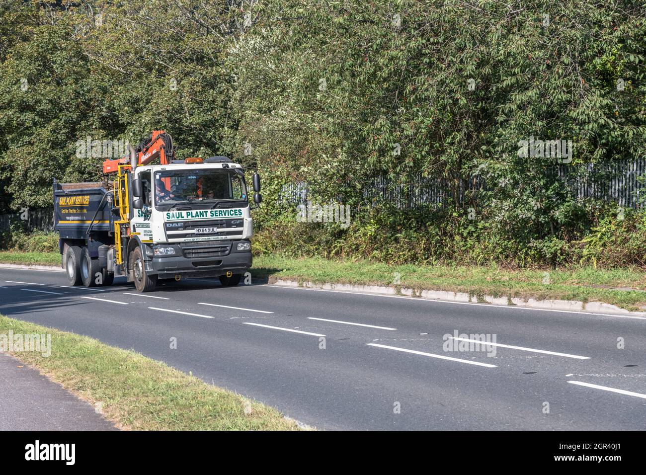 DAF CF 75.310 travelling uphill on a country road. Belongs to a company involved in building trade (/ supplies or plant hire). For UK construction. Stock Photo