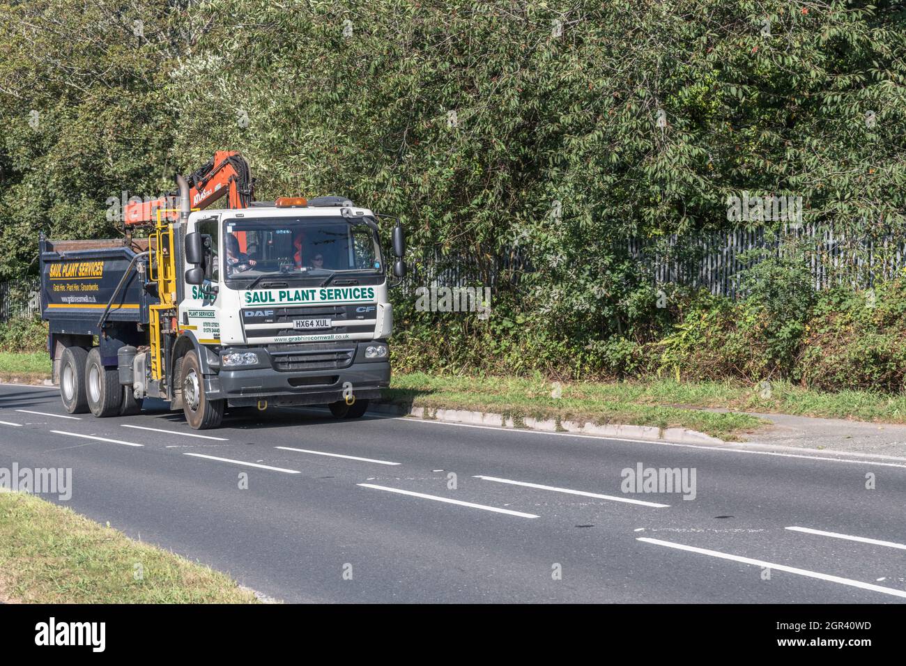 DAF CF 75.310 travelling uphill on a country road. Belongs to a company involved in building trade (/ supplies or plant hire). For UK construction. Stock Photo