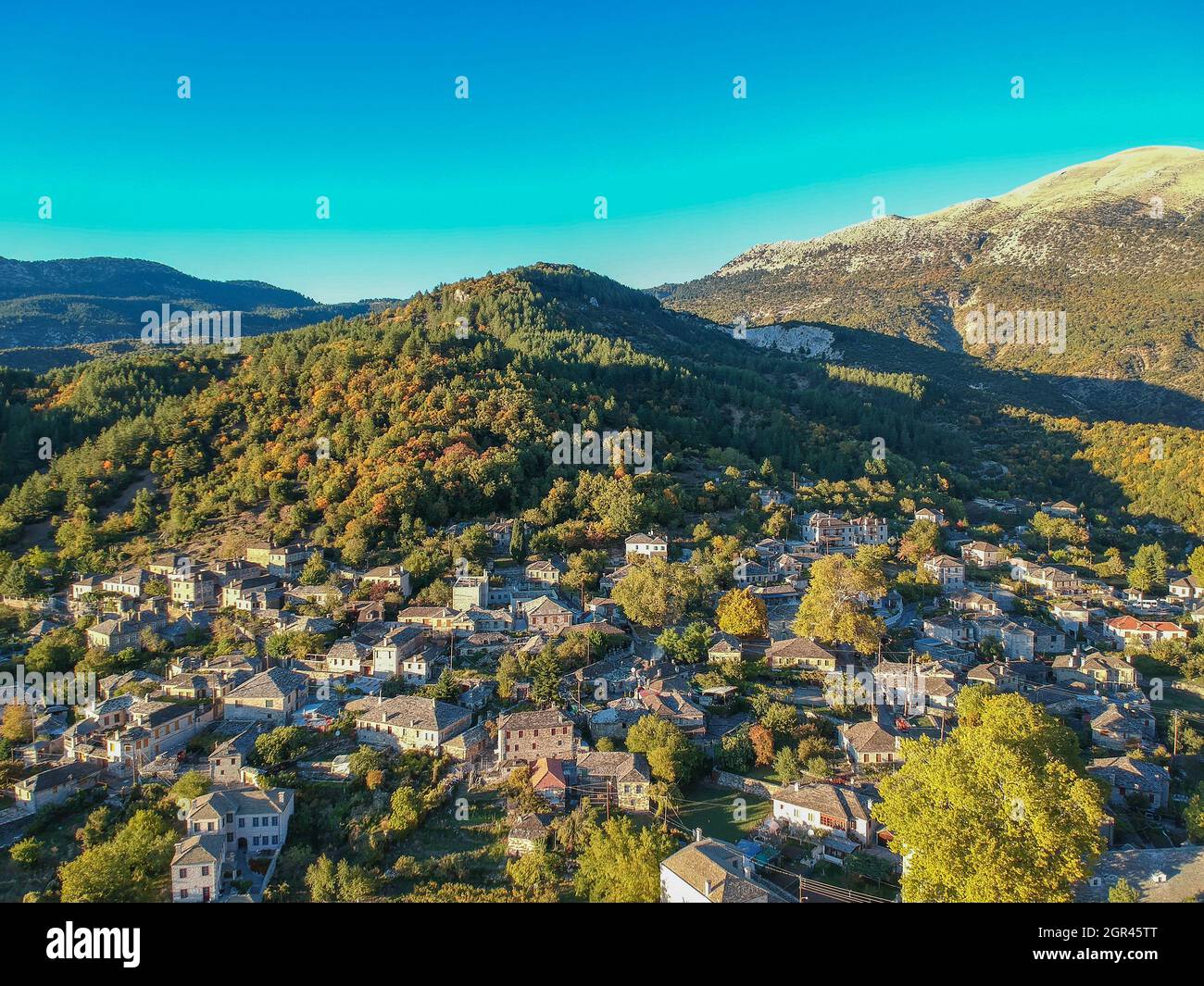Aerial panoramic view over the picturesque village Papigo in Epirus, Greece at sunset. Scenic aerial view of traditional Greek villages in Autumn. Epi Stock Photo