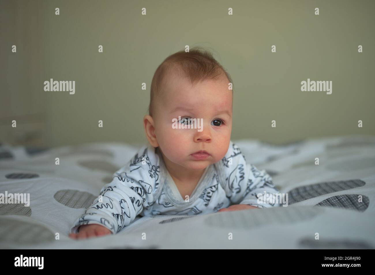 Newborn Baby In Pajamas Relaxing In Bed Stock Photo Alamy