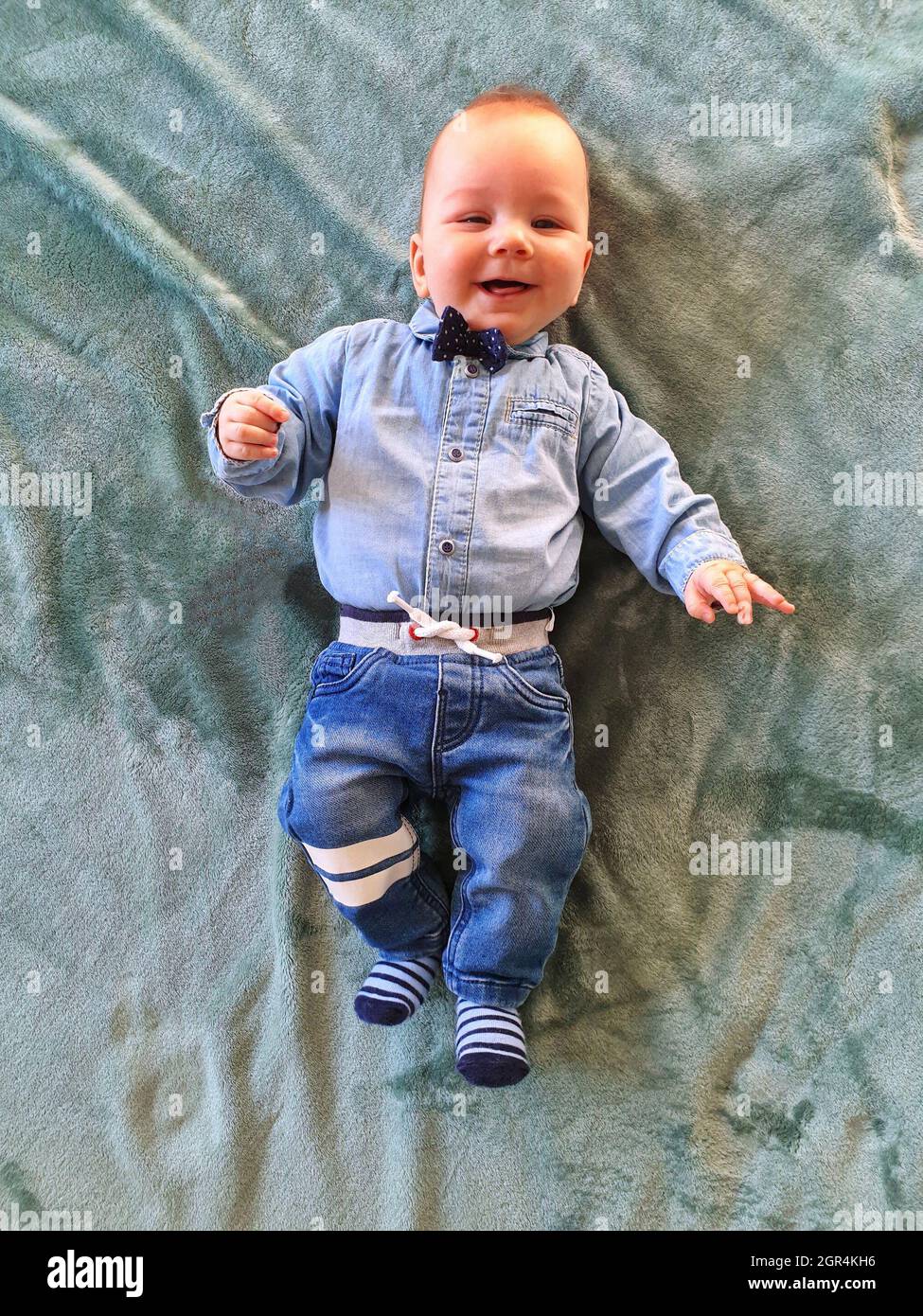 High Angle View Of Newborn Baby In Jeans And Bow Tie Relaxing On Bed Stock  Photo - Alamy