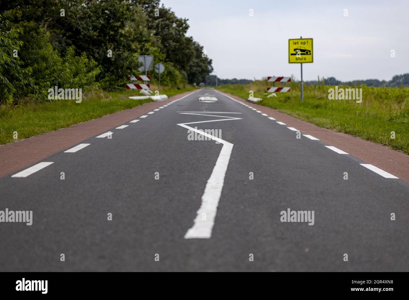 Road lines depicting slow down end of pathway Stock Photo