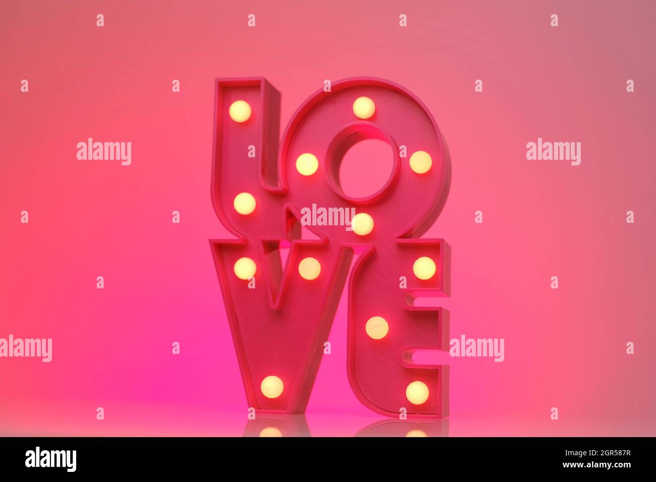 Love.Pink lettering love on a bright neon pink background.Relationships and feelings. Valentine's Day.  Stock Photo
