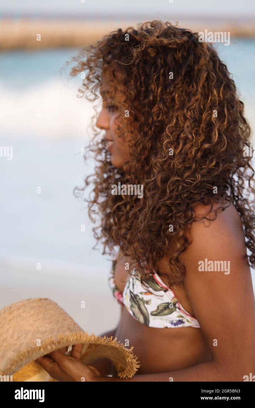Portrait Of Young Woman With Dark Skin And Long Curly Hair At The Beach  Stock Photo - Alamy