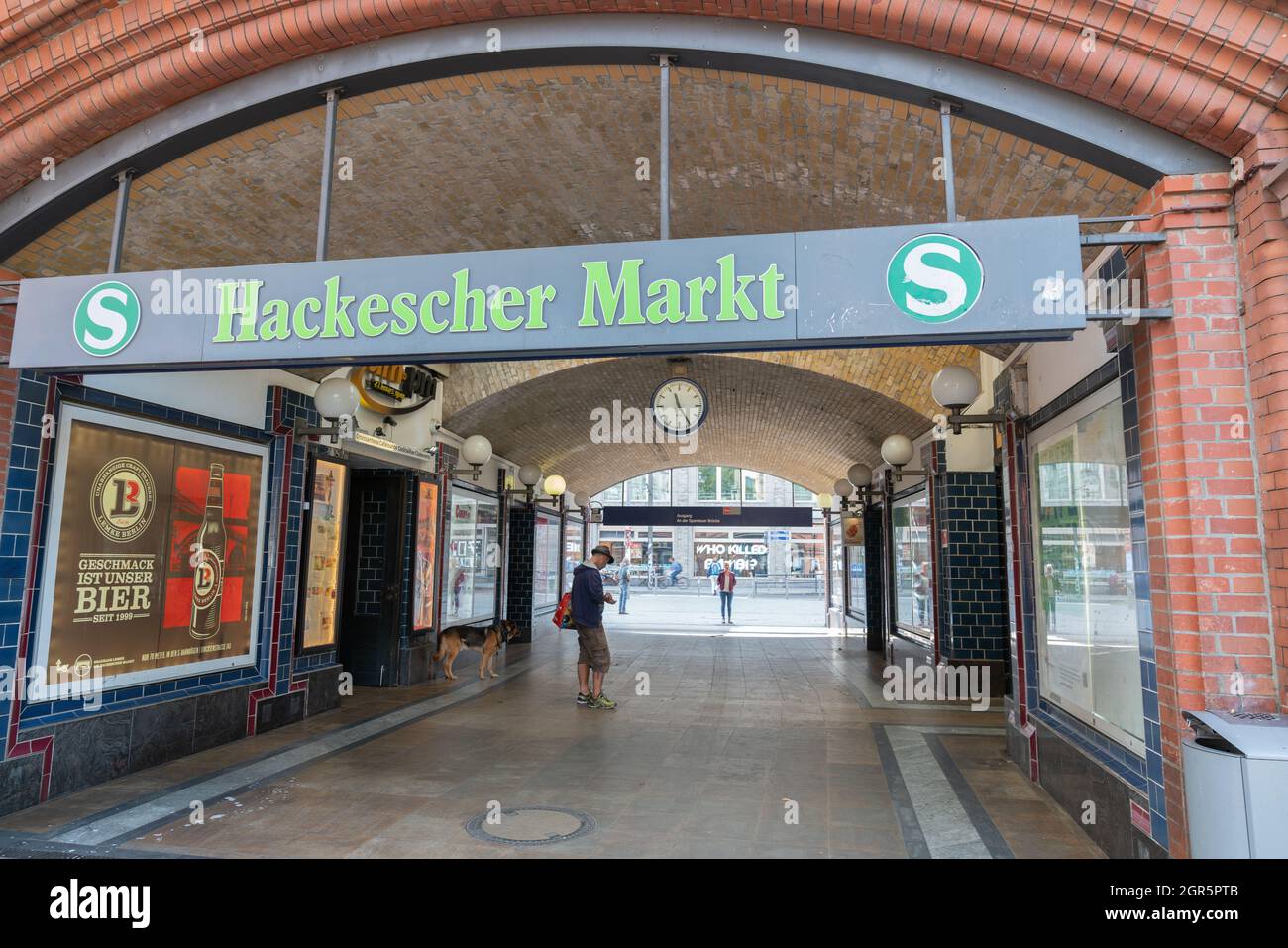 Berlin, Germany - August 27 2017; Man using mobile and dog in popular location Hackescher Market Stock Photo