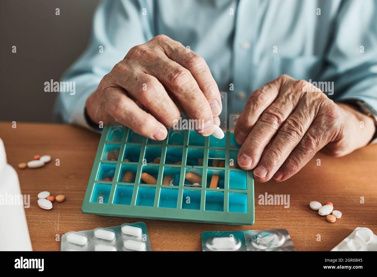 Senior Man Organizing His Medication Into Pill Dispenser. Senior Man