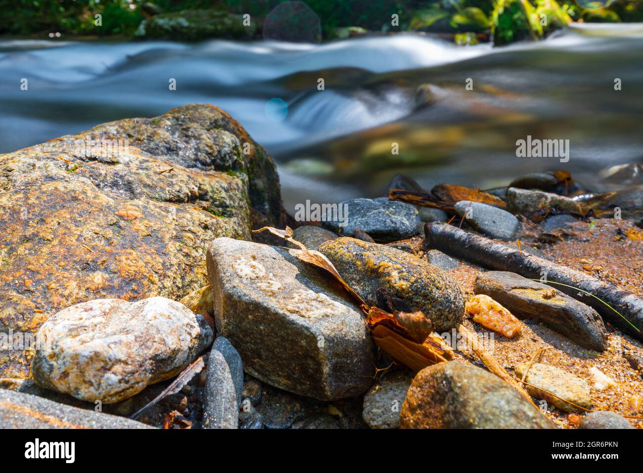 Rocks on the shore of a creek in the mountains. Stock Photo