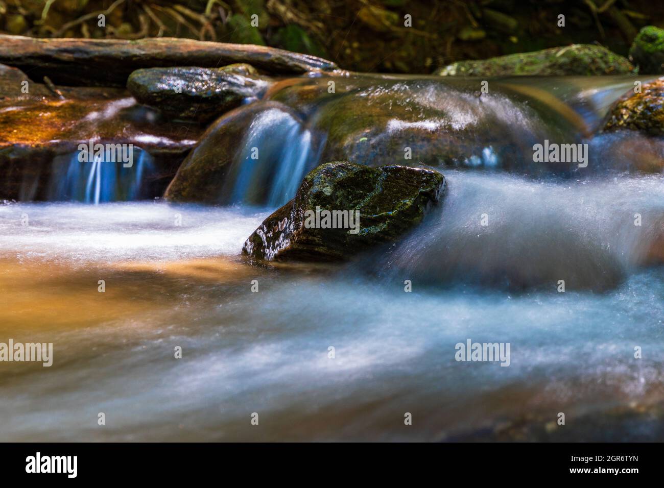 Rocks on the shore of a creek in the mountains. Stock Photo