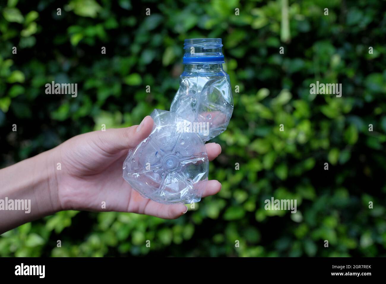 The Hand Shows How To Dispose Of Squeezed Plastic Bottles To Make It