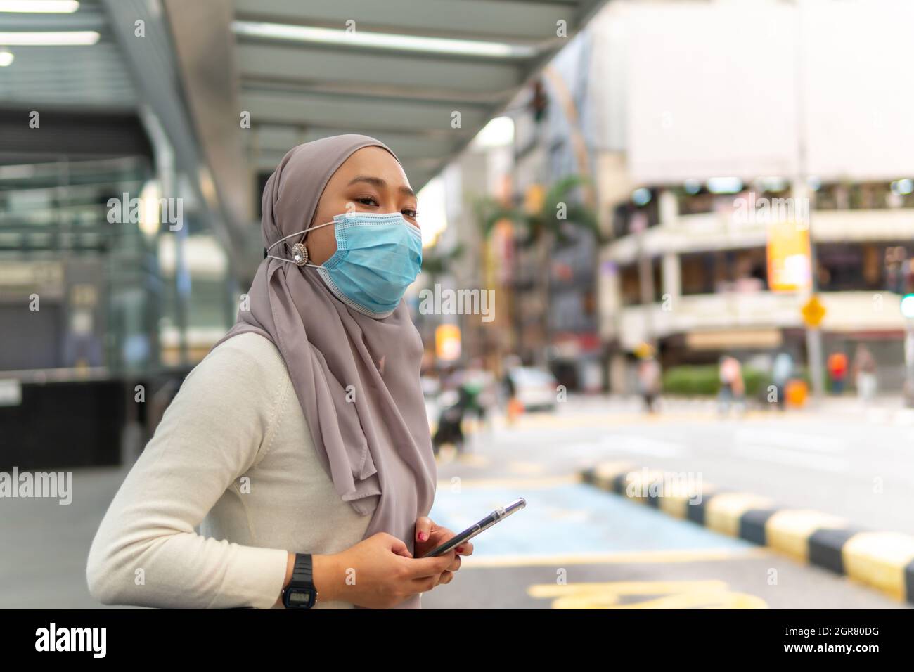 E Hailing Concept Beautiful Malay Girl Holding Smartphone Outdoor At The Taxi Stop Stock Photo Alamy
