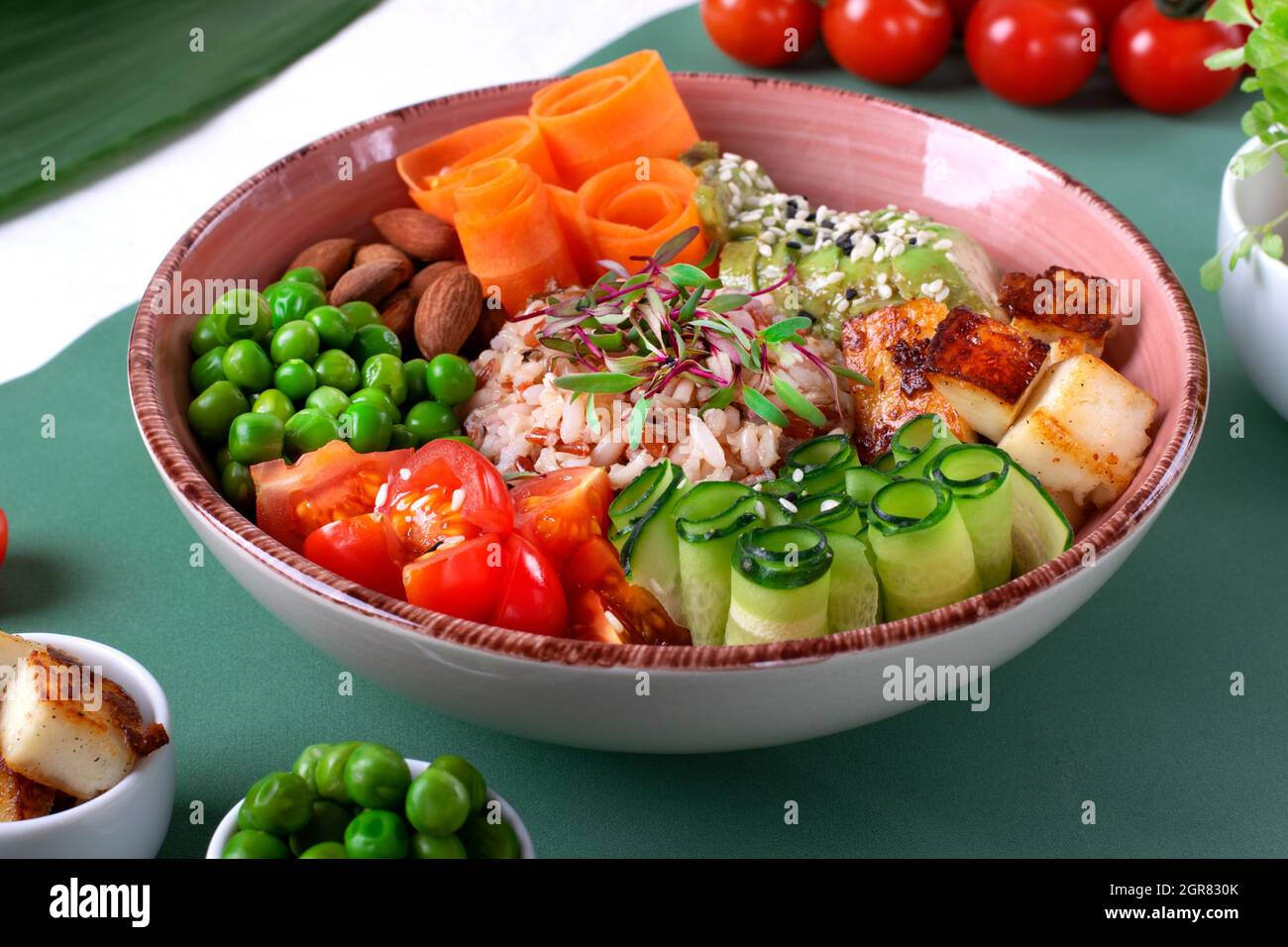 Vegan Poke Bowl With Fried Tofu, Tomato, Carrot, Avocado, Rice, Cucumber, Green Pea And Almond Stock Photo